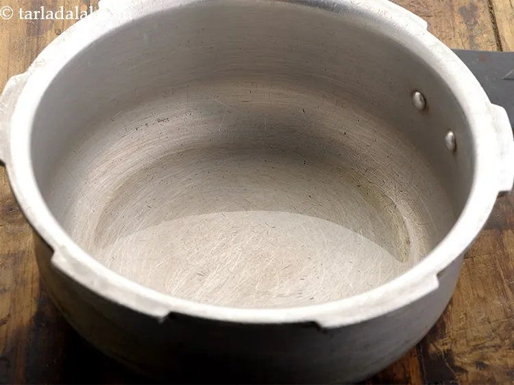 स्टेप 4 – आगे, प्रेशर कुकर में घी गरम करें।