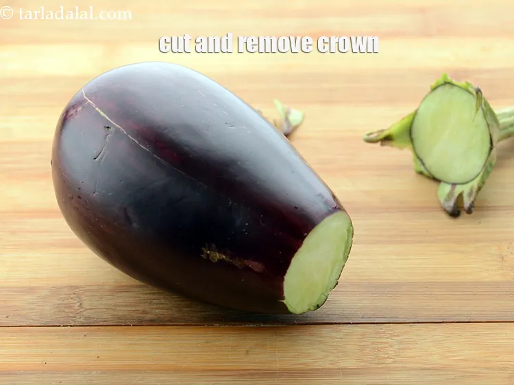 Step 6 – Cut and remove the crown of the brinjal and discard it.&nbsp;