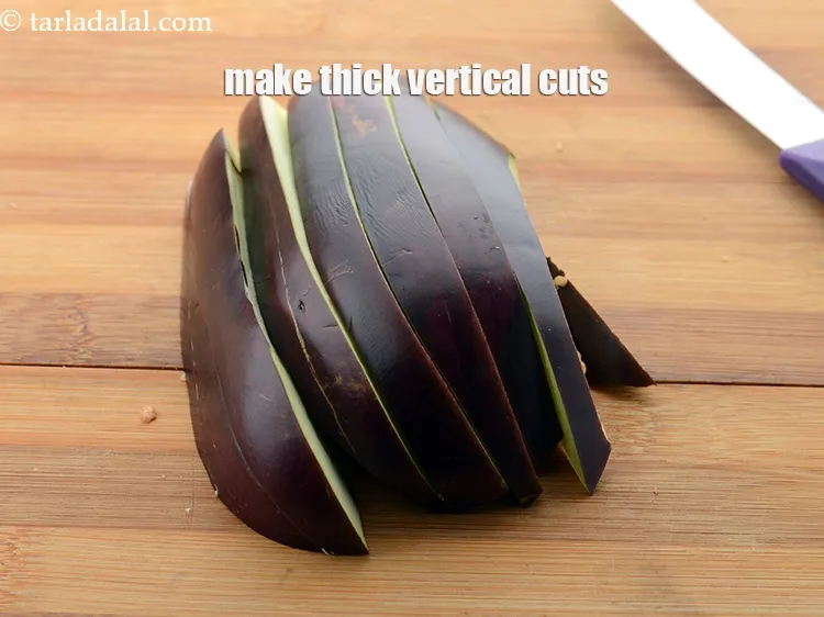 Step 8 – Place 1 halve of the brinjal on the chopping with the flat side facing downwards. …