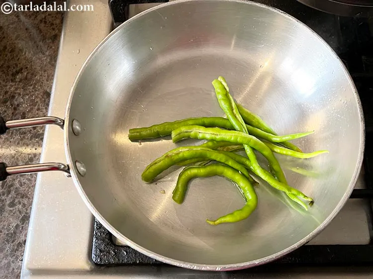 Step 5 – Heat the oil in a broad non-stick pan , add the green chillies.