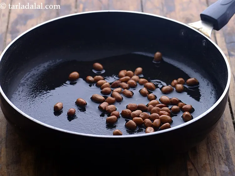 स्टेप 7 – तेल गरम होने के बाद मूंगफली डालें। मूंगफली और चना …