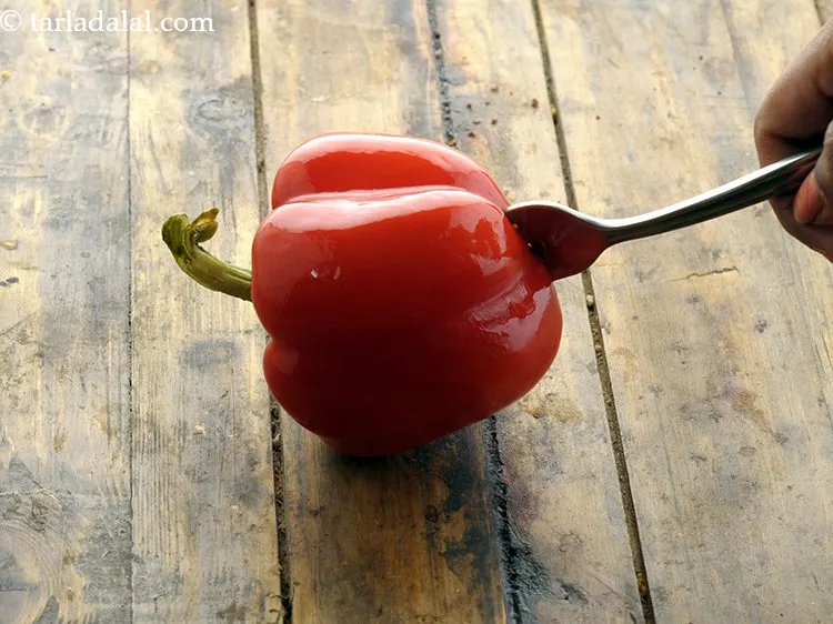 Step 3 – For the capsicum cheese mixture, pierce 1&nbsp;red medium&nbsp;<a href="https://www.tarladalal.com/glossary-capsicum-shimla-mirch-bell-pepper-163i">capsicum</a> with a fork. We are going …