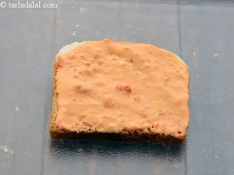 Step 17 – Spread &frac14;th of the capsicum-cheese mixture evenly over it.