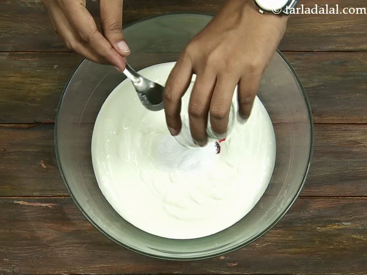 स्टेप 11 – 2 बड़े चम्मच पिसी चीनी डालें। दही के खट्टेपन के …