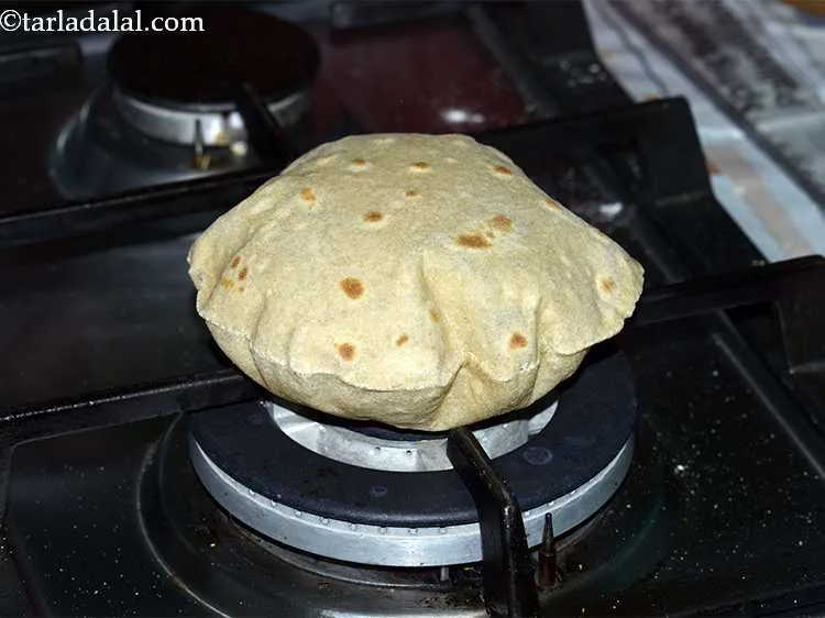 Step 19 – Lift the chapati off the tava with a tong and keep the first side that …