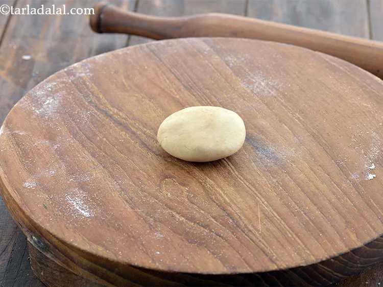 Step 10 – Take a portion of the dough between your palm, flatten it and place it on …