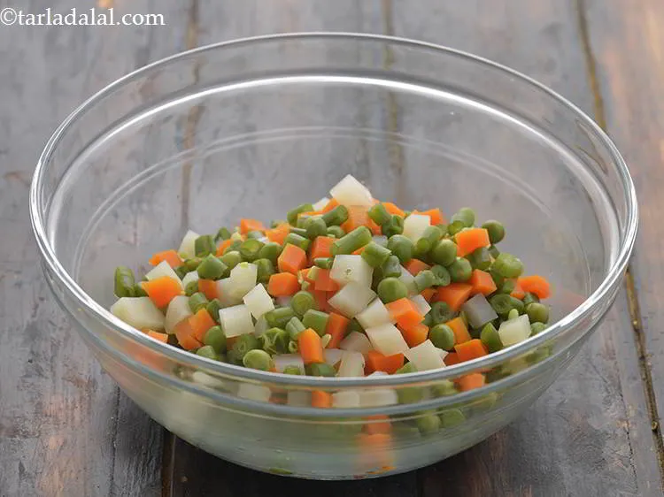 स्टेप 6 – <strong>रशियन सलाद </strong>बनाने के लिए, सब्जियों को एक गहरे कटोरे …