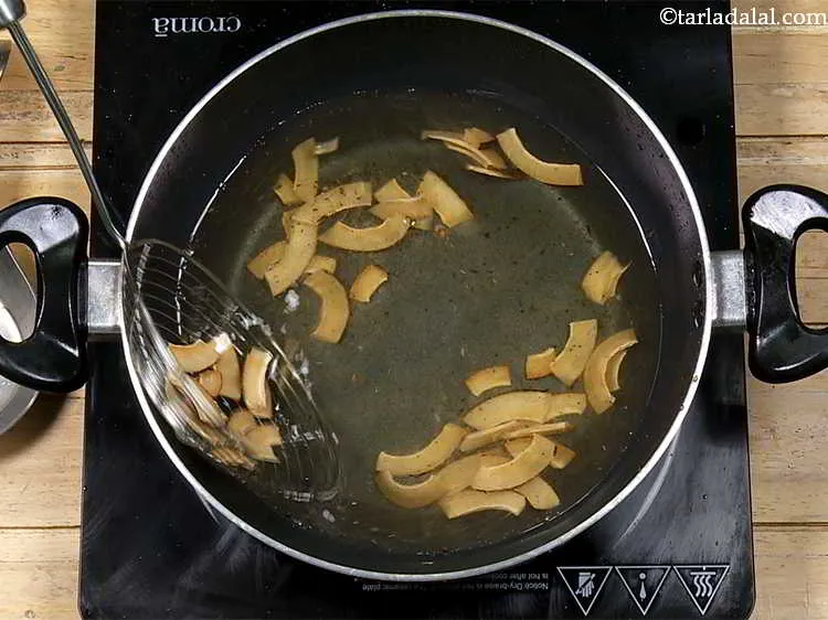 Step 9 – Fry the sliced coconut till they turn golden brown in colour.