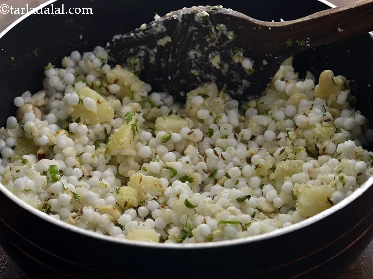 स्टेप 24 – <strong>साबुदाना खिचड़ी</strong> को अच्छी तरह मिलाएं और मध्यम आंच पर …