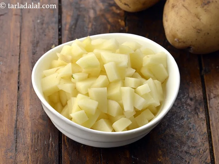 स्टेप 18 – १/२ कप&nbsp;छिले और&nbsp;<a href=""https://www.tarladalal.com/glossary-chopped-potatoes-hindi-787i"">कटे हुए आलू</a> डालें। यह वैकल्पिक है। …