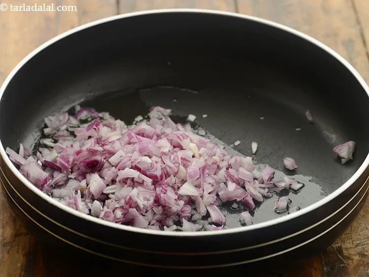स्टेप 15 – तेल गरम होने पर प्याज़ डालें।