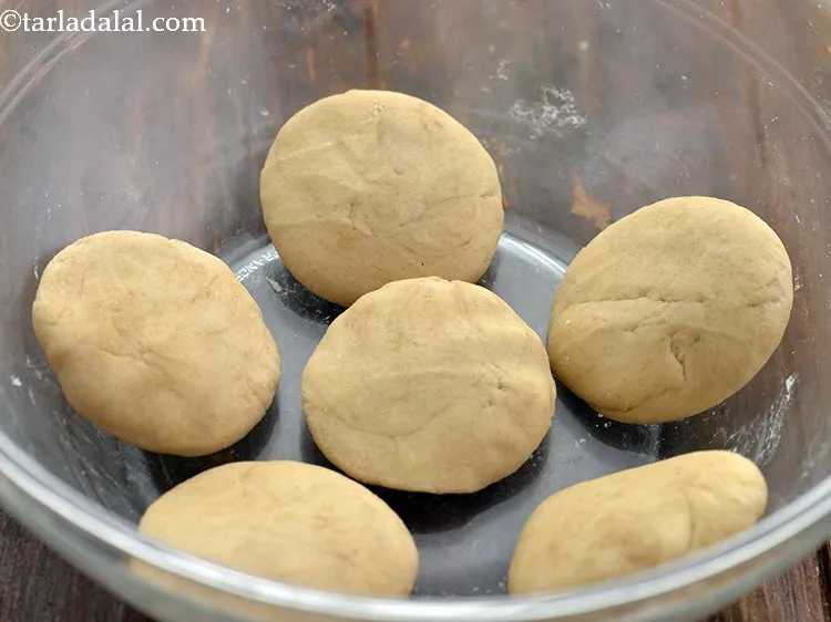 स्टेप 32 – आटे का एक भाग लें, इसे अपनी हथेलियों के बीच …