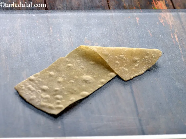 स्टेप 40 – एक समोसा शीट लें और एक त्रिकोण बनाएं।