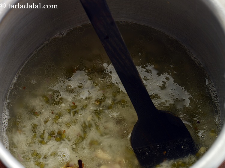 स्टेप 15 – ३ कप गरम पानी डालें। पतली <strong>खिचड़ी</strong> पाने के लिए …