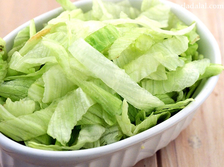 Step 22 – Just before serving, put&nbsp;1 1/2 cups&nbsp;<a href="https://www.tarladalal.com/glossary-shredded-iceberg-lettuce-2188i">shredded iceberg lettuce</a> on a serving plate.