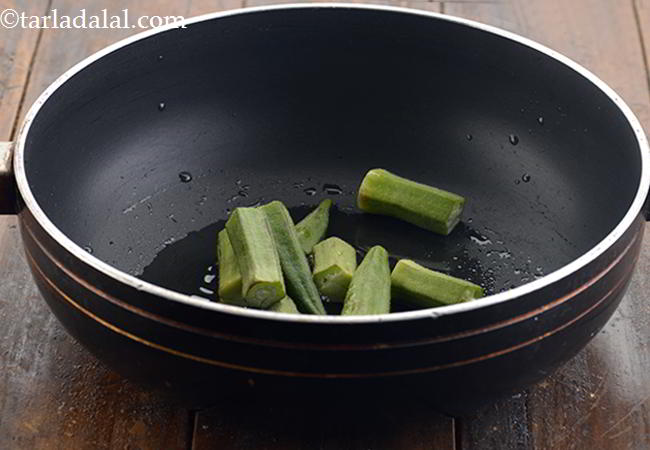 स्टेप 9 – इसमें भिन्डी डालें। भिन्डी के उपर के हिस्से को काटा …