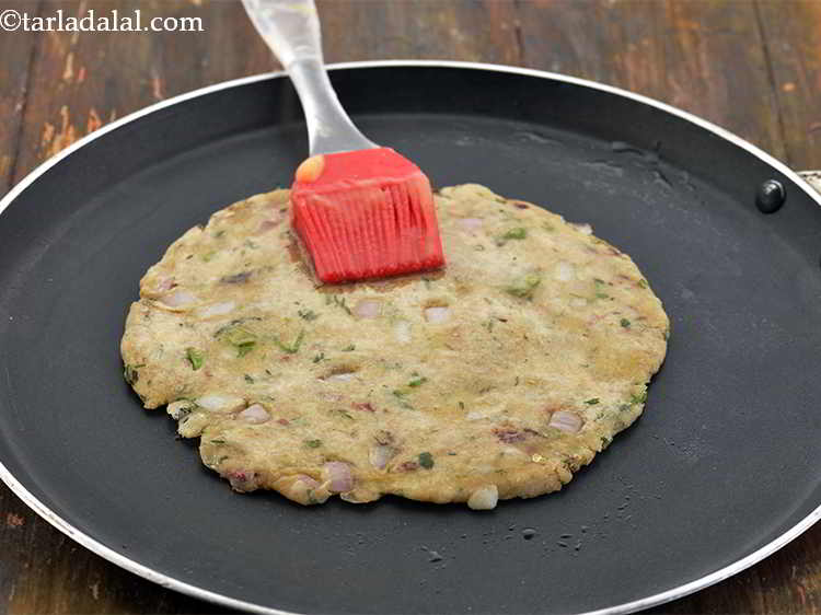 Step 21 – Apply 1 tsp of ghee and cook on one side till&nbsp;<strong>Sindhi Koki</strong>&nbsp;turns golden brown in …