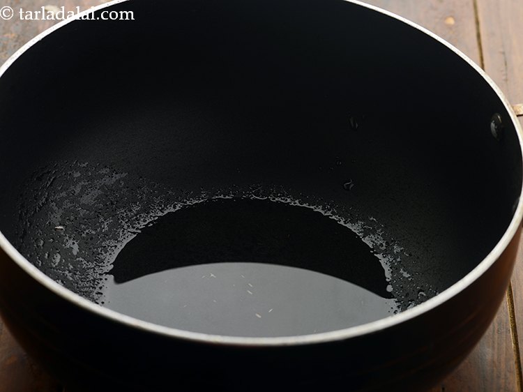 Step 1 – To make <strong>spicy chapati cooked in buttermilk</strong>, heat oil in a deep non-stick pan.