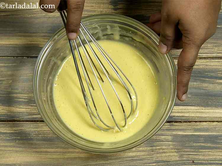 स्टेप 4 – एक व्हिस्क का उपयोग करके, गांठ रहित मुलायम घोल बनाने …