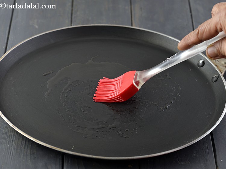 Step 11 – For making the&nbsp;&nbsp;<strong>Indian Oats Pancake with Jowar</strong>, heat a non-stick tava (griddle) and grease it …