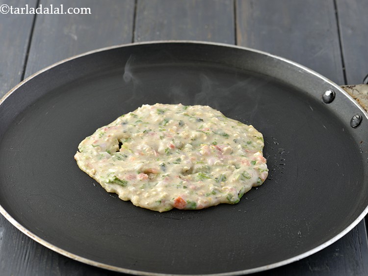 Step 12 – Pour a ladleful of the batter on the tava (griddle). Spread in a circular motion …