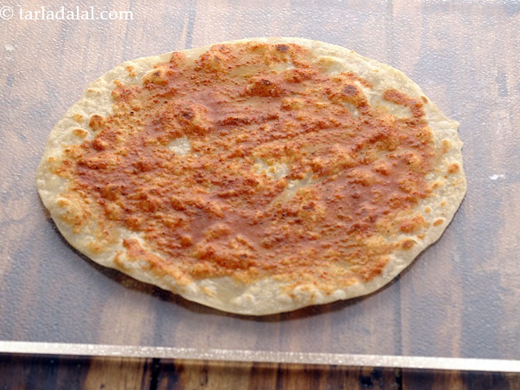 Step 41 – Spread &frac12; tbsp of the masala water evenly over it.