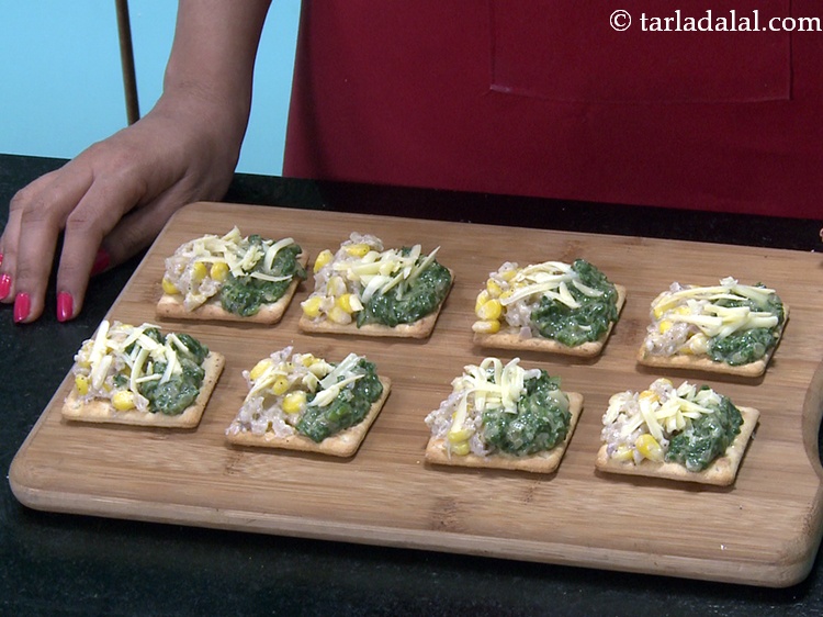 Step 34 – Finally sprinkle &frac12; tsp of&nbsp;<a href="https://www.tarladalal.com/glossary-grated-processed-cheese-868i">grated processed cheese</a> evenly over each cracker biscuit.