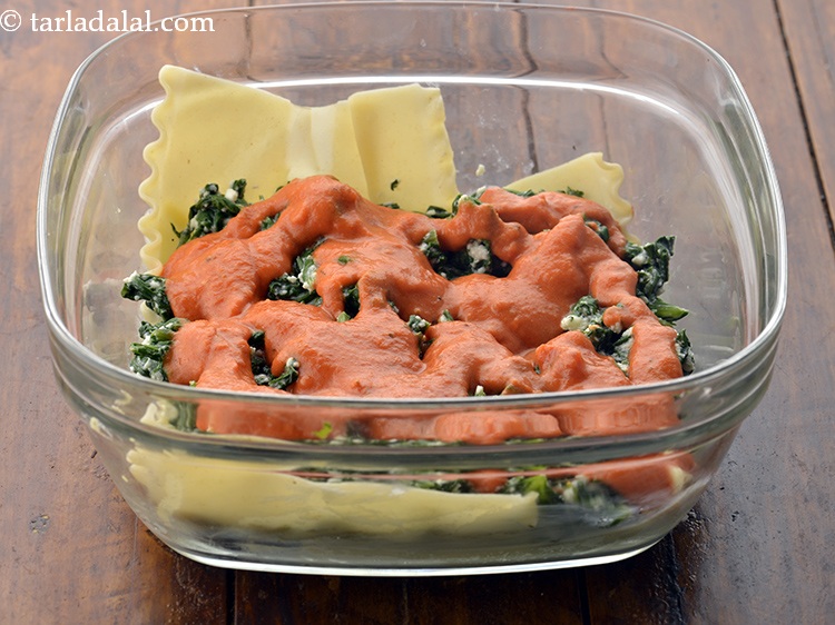 Step 59 – Spread half the&nbsp;spinach mixture and half the&nbsp;tomato sauce evenly over it.