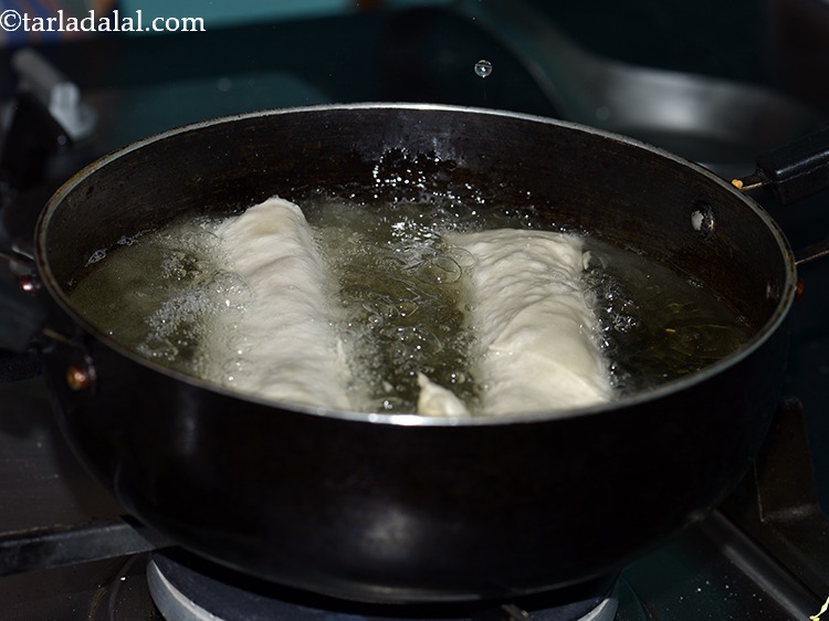 Step 25 – Heat the oil in a deep non- stick pan. Drop a small piece of wrapper, …