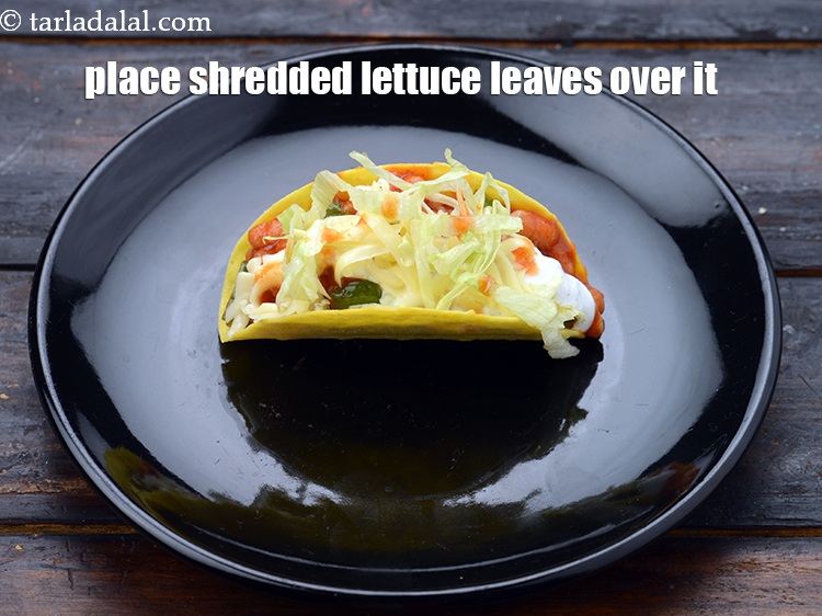 Step 25 – Place some <a href="https://www.tarladalal.com/glossary-shredded-lettuce-856i">shredded lettuce leaves</a> over it.