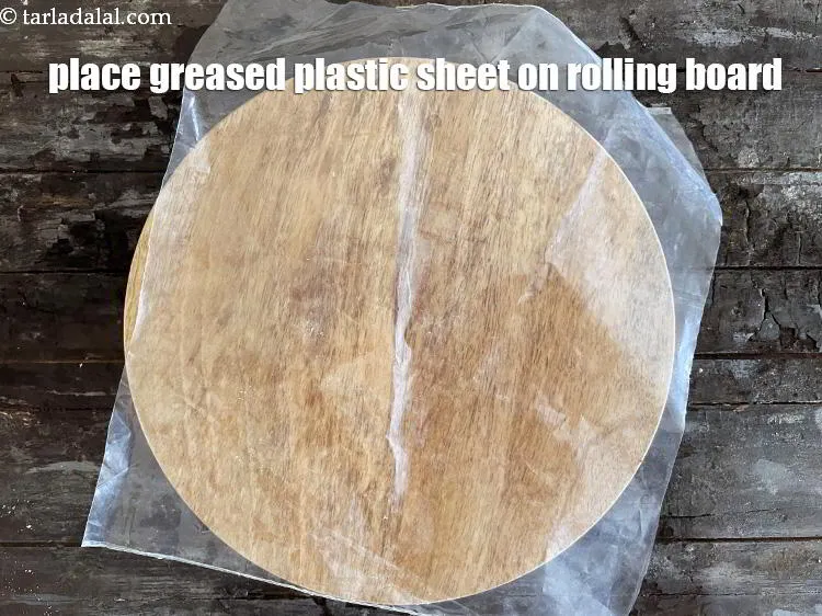 Step 15 – Place one greased plastic sheet on the rolling board.