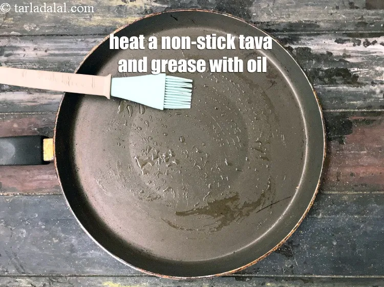 Step 15 – <html><head><meta charset="UTF-8"></head><body><p>Heat a non-stick tava (griddle) and grease it with oil.&nbsp;&nbsp;</p></body></html>