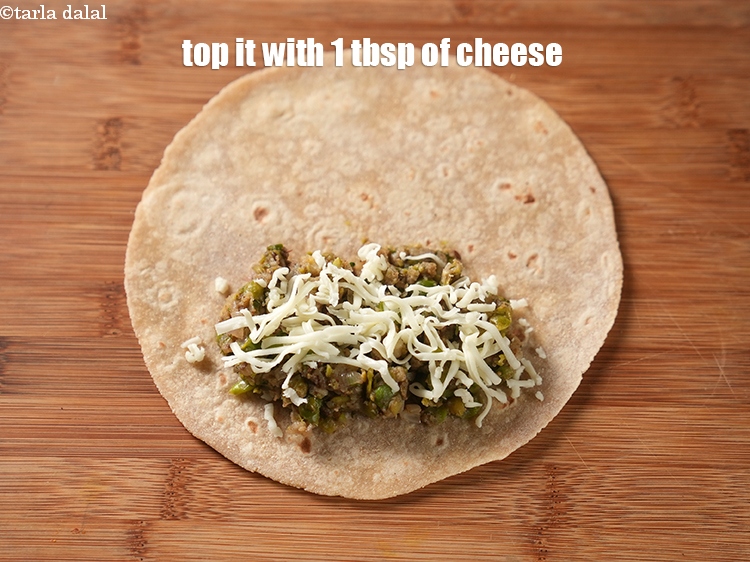 स्टेप 26 – इसके ऊपर समान रूप से 1 टेबल-स्पून&nbsp;<a href=""https://www.tarladalal.com/glossary-grated-processed-cheese-hindi-868i"">कसा हुआ प्रोसेस्ड …