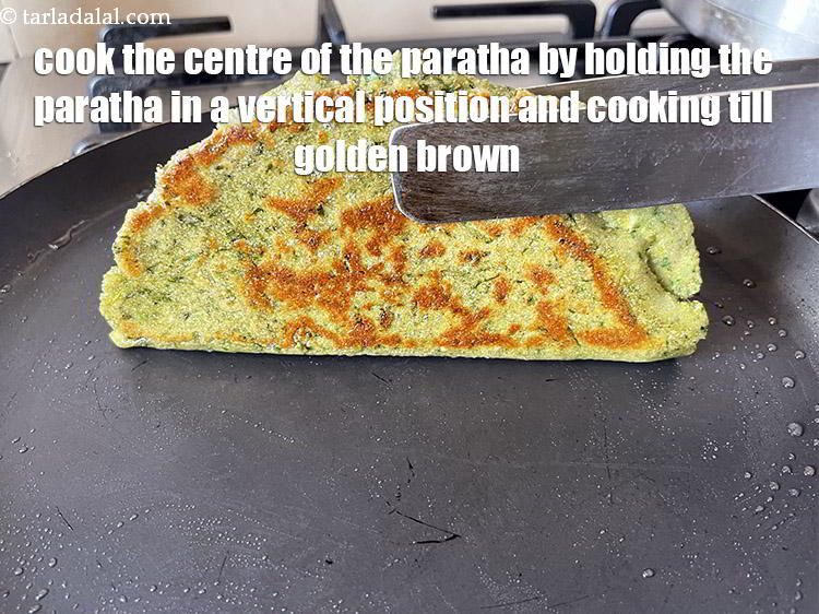 Step 34 – Cook the centre of the paratha by holding the paratha with a pair of tongs …