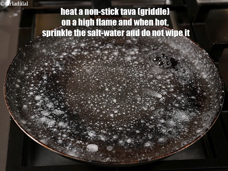 Step 37 – Heat an iron tava (griddle), and sprinkle some salt water on a hot iron tava …