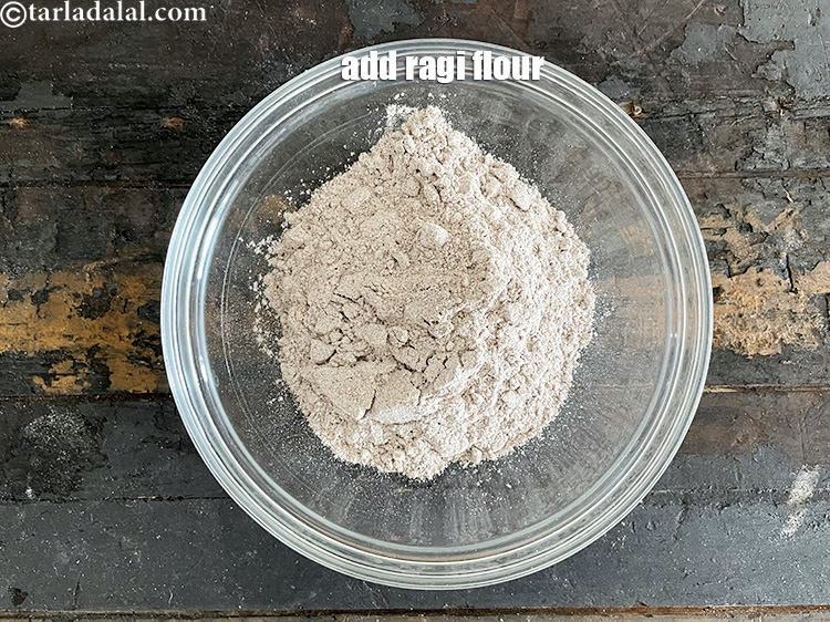 Step 13 – In a deep glass bowl put&nbsp;<meta charset="UTF-8" />1 cup&nbsp;<a href="glossary-ragi-flour-nachni-flour-nachni-ka-atta-red-millet-flour-1115i">ragi (nachni / red millet) flour</a>.