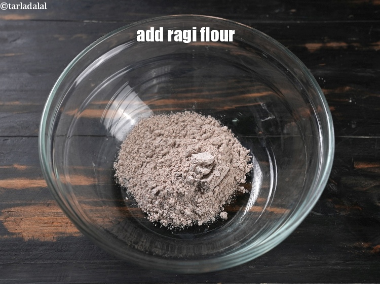 Step 3 – To make <strong>baked ragi chakli</strong>, in a deep bowl, add &frac14; cup&nbsp;<a href="https://www.tarladalal.com/glossary-ragi-flour-nachni-flour-nachni-ka-atta-red-millet-flour-1115i">ragi (nachni / …