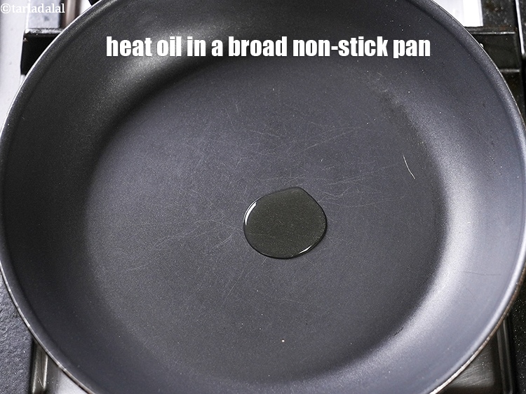 Step 3 – To make <strong>gula ruti recipe</strong>, heat &frac12; tsp oil in a broad non-stick pan.