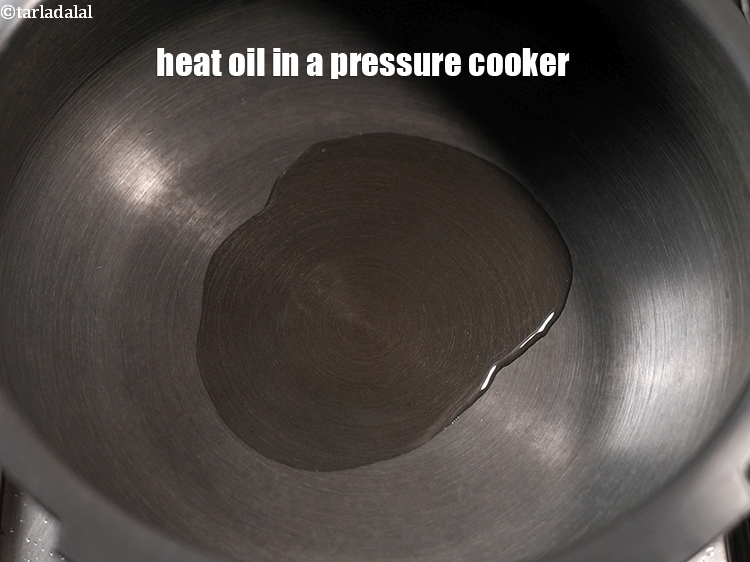 Step 3 – To make <strong>aloo baingan masala</strong>, heat 3 tbsp oil in a pressure cooker.