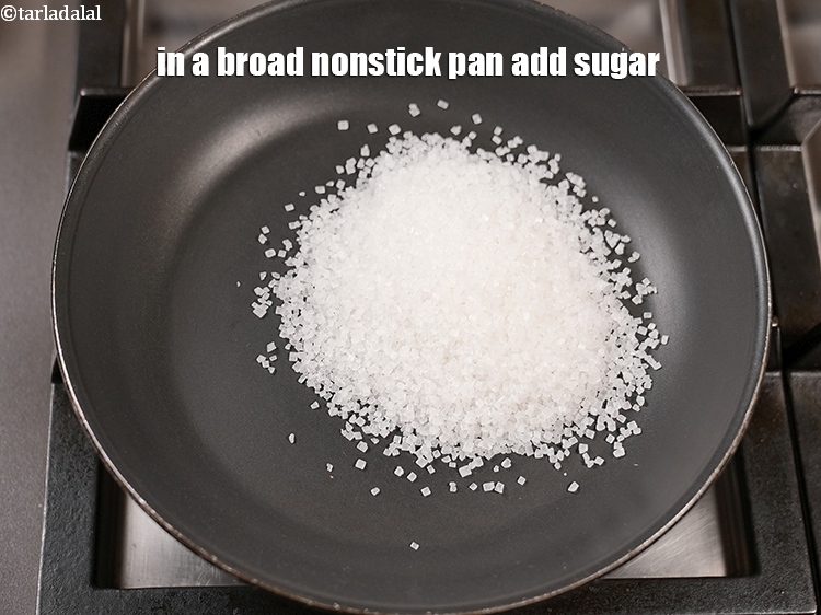 स्टेप 3 – एक चौड़े नॉनस्टिक पैन में १/२ कप&nbsp;<a href=""https://www.tarladalal.com/glossary-powdered-sugar-hindi-280i"">पिसी हुई चीनी</a>&nbsp;डालें …