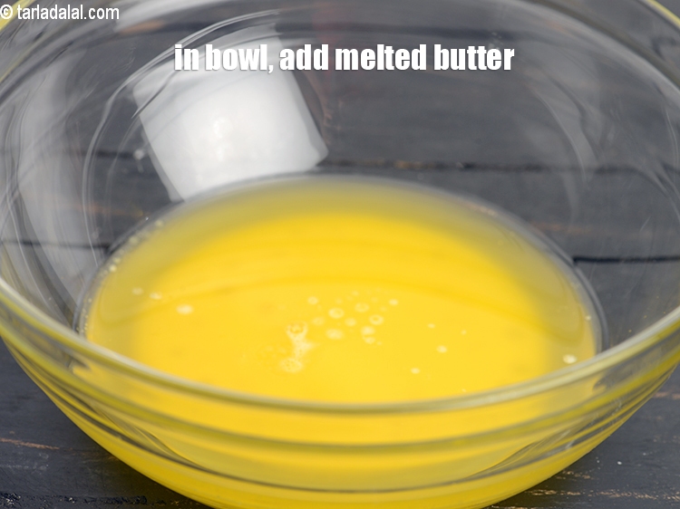 Step 4 – To make <strong>eggless cheesecake brownie</strong>, in a deep bowl, add 1/2 cup <a href="https://www.tarladalal.com/glossary-melted-butter-1941i">melted butter</a>.