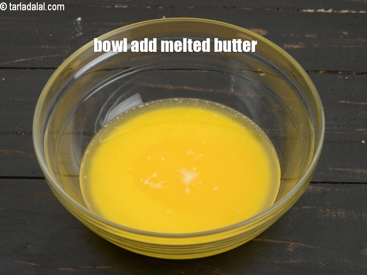 Step 4 – To make <strong>eggless orange muffins</strong>, in a deep bowl add &frac12; cup <a href="https://www.tarladalal.com/glossary-melted-butter-1941i">melted butter</a>.