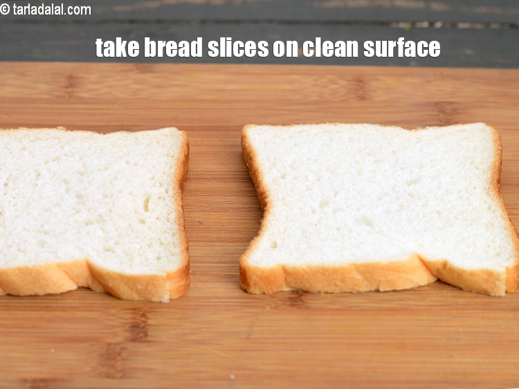 Step 4 – Take 2 <a href="https://www.tarladalal.com/glossary-bread-219i">bread</a>&nbsp;slices on a clean, dry surface.&nbsp;