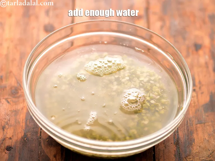 Step 20 – Transfer the soaked and drained dal into another deep bowl. Add enough water for soaking.&nbsp;