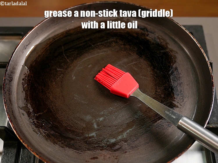 Step 12 – Grease a non-stick tava (griddle) with a little oil.