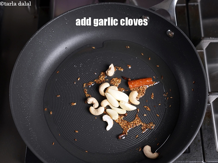 Step 12 – Add 5 <a href="https://www.tarladalal.com/glossary-garlic-cloves-1857i">garlic (lehsun) cloves</a>.