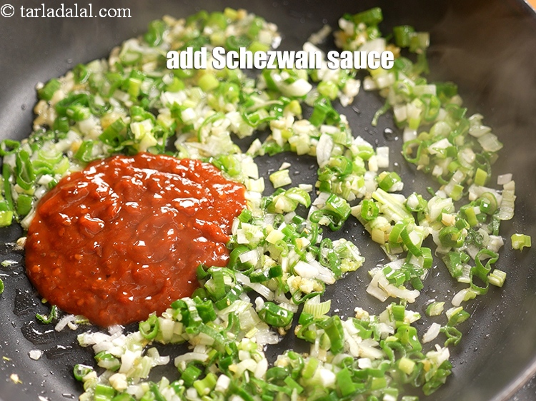 Step 12 – Add &frac14; cup <a href="https://www.tarladalal.com/glossary-schezwan-sauce-schezuan-sauce-1872i">schezwan sauce</a>.