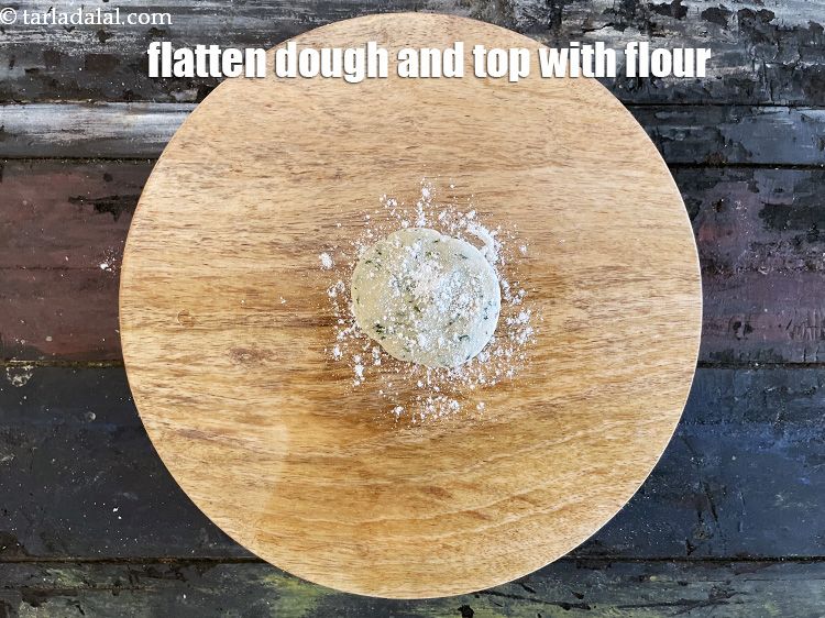 Step 14 – Sprinkle a little&nbsp;<a href="https://www.tarladalal.com/glossary-whole-wheat-flour-gehun-ka-atta-gehun-ka-aata-429i">whole wheat flour (gehun ka atta)</a>&nbsp; on the rolling surface.&nbsp;Flatten the dough …