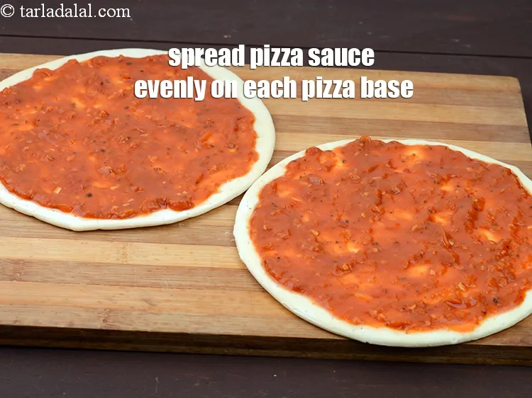 Step 20 – Spread half the pizza sauce evenly on each pizza base.