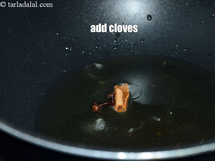 Step 12 – Add 2 <a href="https://www.tarladalal.com/glossary-cloves-laung-lavang-322i">cloves (laung / lavang)</a>.